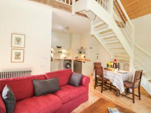 a living room with a red couch and a table at Ucheldref in Corwen