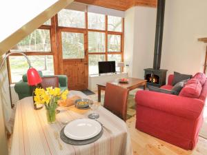 a living room with a table and a fireplace at Ucheldref in Corwen