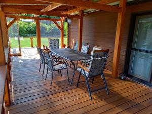 a table and chairs on a wooden deck at NaposOldal Vendégház in Tapolca