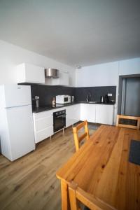 a kitchen with white cabinets and a wooden table at JOE BAY in Saint Malo