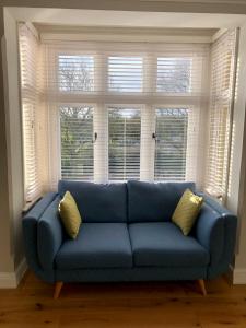 a blue couch sitting in front of a window at Stunning 2 Bed Georgian Apartment in Swafield