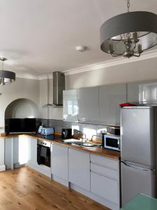 a kitchen with stainless steel appliances and wooden floors at Stunning 2 Bed Georgian Apartment in Swafield