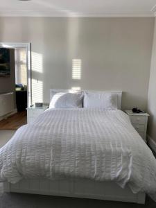 a white bed with a white comforter in a bedroom at Stunning 2 Bed Georgian Apartment in Swafield