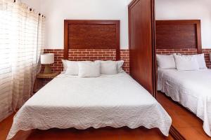 een slaapkamer met twee bedden met witte lakens bij Fabiola Condo Hotel in Playa del Carmen