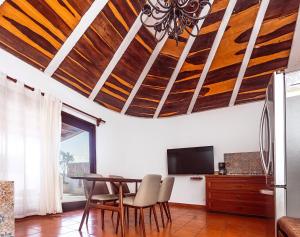 a dining room with wooden ceilings and a table and chairs at Fabiola Condo Hotel in Playa del Carmen