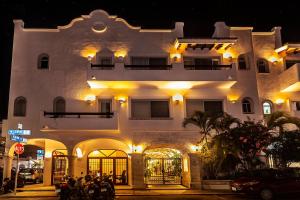un gran edificio blanco con motocicletas estacionadas frente a él en Fabiola Condo Hotel, en Playa del Carmen
