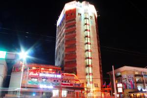 a tall building with lights on it at night at Narantuul Hotel in Ulaanbaatar