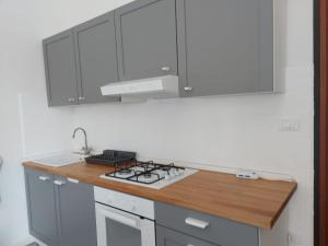 a kitchen with white cabinets and a stove top oven at Olly&Asia home in Imola +2 photos