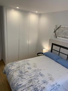 a bedroom with a bed with a blue and white blanket at Acogedora Casa con Patio en El Tiemblo (Ávila) in El Tiemblo