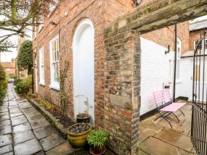 a brick building with a bench and plants on a patio at Magdalene House in Louth