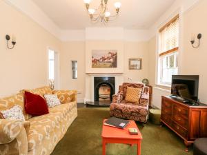 a living room with a couch and a fireplace at Magdalene House in Louth