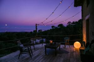 une terrasse avec des chaises, une table et un coucher de soleil dans l'établissement Eco Gîte avec vue sur mer, à Chiatra