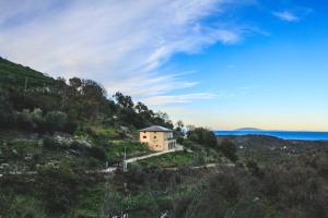 une maison sur une colline à côté de l'océan dans l'établissement Eco Gîte avec vue sur mer, à Chiatra