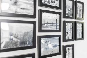 einer Wand mit gerahmten Bildern in der Unterkunft Rothen Huus in Norderney
