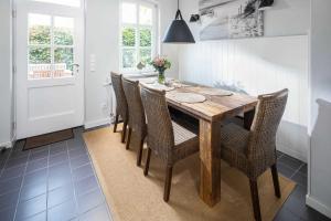 ein Esszimmer mit einem Holztisch und Stühlen in der Unterkunft Rothen Huus in Norderney