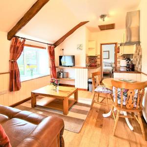 uma sala de estar com um sofá e uma mesa em Ta Mill Cottages & Lodges - Smithy Cottage em Launceston