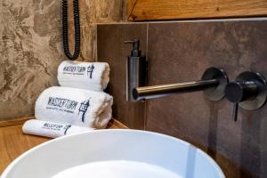 a bathroom with a white sink and a pile of towels at Apartment Suite - a57366 in Bad Segeberg