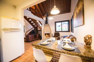 cocina y sala de estar con mesa y chimenea en Casa na Barra de Ibiraquera en Barra de Ibiraquera