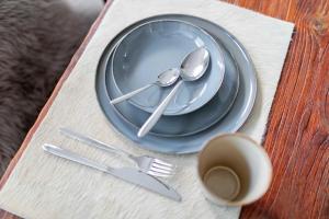 a blue plate with spoon and fork and a cup of coffee at Seehaus 48 in Norderney