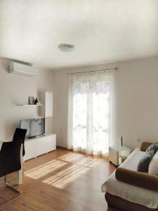 a living room with a couch and a window at lino in Ivan Dolac