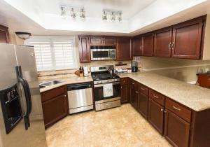 una cocina con armarios de madera y electrodomésticos de acero inoxidable en Cozy home in quiet neighborhood en Las Vegas