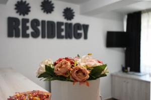 a white vase with a bouquet of flowers in it at Pension Recidency in Oradea