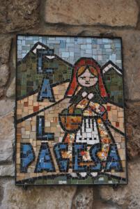 une mosaïque d'une femme sur un mur dans l'établissement Ca la Pagesa, à Sant Llorenc de Morunys