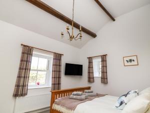 una camera da letto con un letto e un lampadario di 1 Hull House Cottage a Skipton