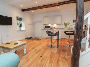 una cucina e un soggiorno con tavolo e sgabelli di 3 Hull House Cottage a Skipton