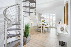 a spiral staircase in a living room with a table at Strandperle Ney in Norderney