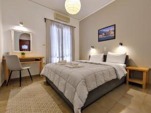 a bedroom with a large bed with a desk and a chair at Hotel Aegina in Aegina Town