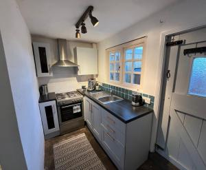 a kitchen with a sink and a stove at Bay Cottage, Hot Tub in Snitterfield