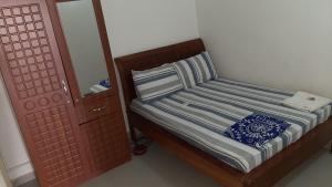 - un petit lit dans une chambre avec un miroir dans l'établissement Aziz Gaff, à Dakar