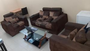 un salon avec un canapé et une table avec un ordinateur portable dans l'établissement Aziz Gaff, à Dakar