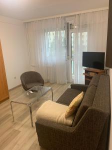 a living room with a couch and a glass table at Szabó Apartman in Miskolc