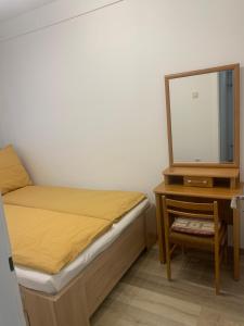 a bedroom with a bed and a dresser and a mirror at Szabó Apartman in Miskolc