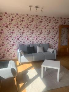 a living room with a couch and flowers on the wall at Mirador de Valcayo in Riaño