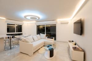 a living room with a white couch and a table at Le Petit Prince: Appartement de haut standing in Beausoleil