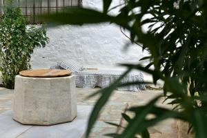 a bench sitting in a courtyard with a table at Sterna Apartment in Hydra