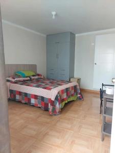 1 dormitorio con 1 cama y suelo de madera en Hospedaje Kelita en Moquegua
