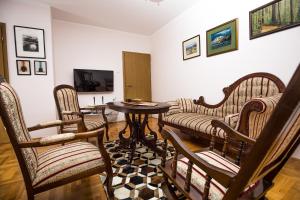 - un salon avec des chaises, une table et une télévision dans l'établissement Apartment Sole, à Cetinje