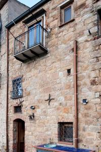 un edificio de ladrillo con un balcón en el lateral. en Mirose's holiday home en Castelbuono