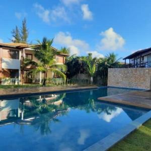 a swimming pool in front of a house at Apartamento Portofino in Barra Grande