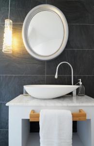 uma casa de banho com um lavatório branco e um espelho. em Despoina Apartment em Patitiri