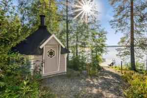 Kosula哈提图维特山林小屋的湖边的一座黑色屋顶的小房子