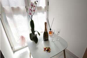 TerzignoにあるAffittacamere Vesuvioの白いテーブル(ボトル1本、グラス2枚、花)