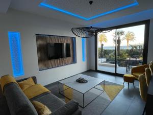 a living room with a couch and a tv and a table at Luxury Garden Jacuzzi Promenade in Nice
