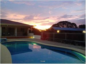 einen Pool mit Sonnenuntergang im Hintergrund in der Unterkunft Hermosa Paradise in Playa Hermosa
