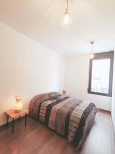 um quarto com uma cama, uma mesa e uma janela em Casa Kimo Platja em Vilanova i la Geltrú