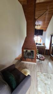 a living room with a brick fireplace in a room at Hotel Serra Bonita in Delfim Moreira